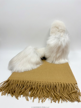 Premium camel-colored 100% baby alpaca throw blanket with fringe, paired with white Suri alpaca fur slippers in a professional studio setting.