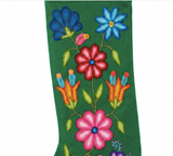 A green embroidered stocking featuring colorful floral patterns including pink, blue, orange, and yellow flowers with green leaves on a white background.