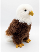 Side view of an alpaca fur bald eagle stuffed animal showing its white tail and brown wings.