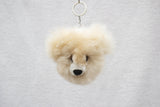A beige alpaca fur keychain shaped like a bear with fluffy ears and a black nose.