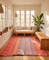 Archival Textile No. 109: A large vintage Peruvian Frazada rug featuring a terracotta and lavender diamond weave. This one-of-a-kind hand-loomed wool rug is shown on a white background, highlighting its rare scalloped crochet edge and central union seam.