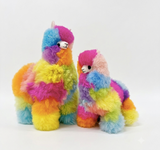 Two colorful fuzzy alpaca fur plush toys in different sizes, decorated with rainbow stripes of pink, blue, yellow, green, orange, and purple, set against a plain white background.