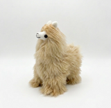 Long hair alpaca plush toy in light tan and cream, sitting on a seamless white studio background.