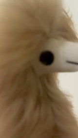 A short video demonstrating the long, high-luster beige fur of a 12-inch handmade Suri alpaca plush toy moving gracefully in the wind, showcasing its silky texture and natural fiber quality.