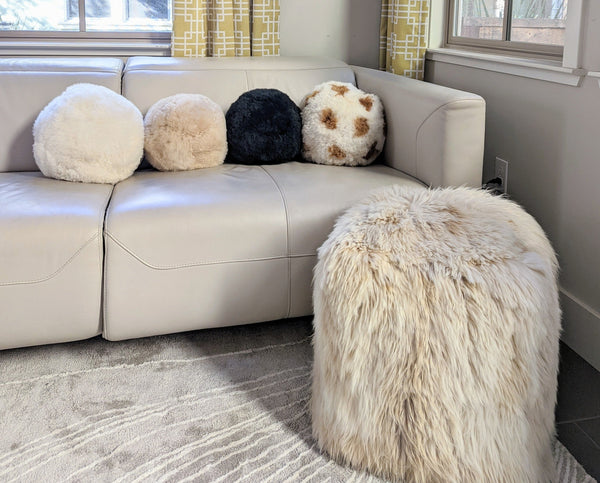 Four round alpaca fur ball pillows in white, beige, black and mixed color, handmade in Peru.
