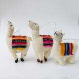 Set of three hand-knitted alpaca yarn llama Christmas ornaments, each with a different head position and a colorful woven textile accent on its back, handmade in the Andes of Peru