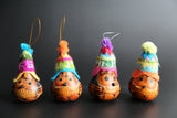 A set of three handcrafted owl-shaped gourd ornaments with colorful hand-knitted hats resembling traditional Andean hats.