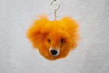 An orange alpaca fur keychain in the shape of a bear.