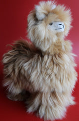 Close-up of silky Suri alpaca stuffed animal with long white locks handmade in Peru
